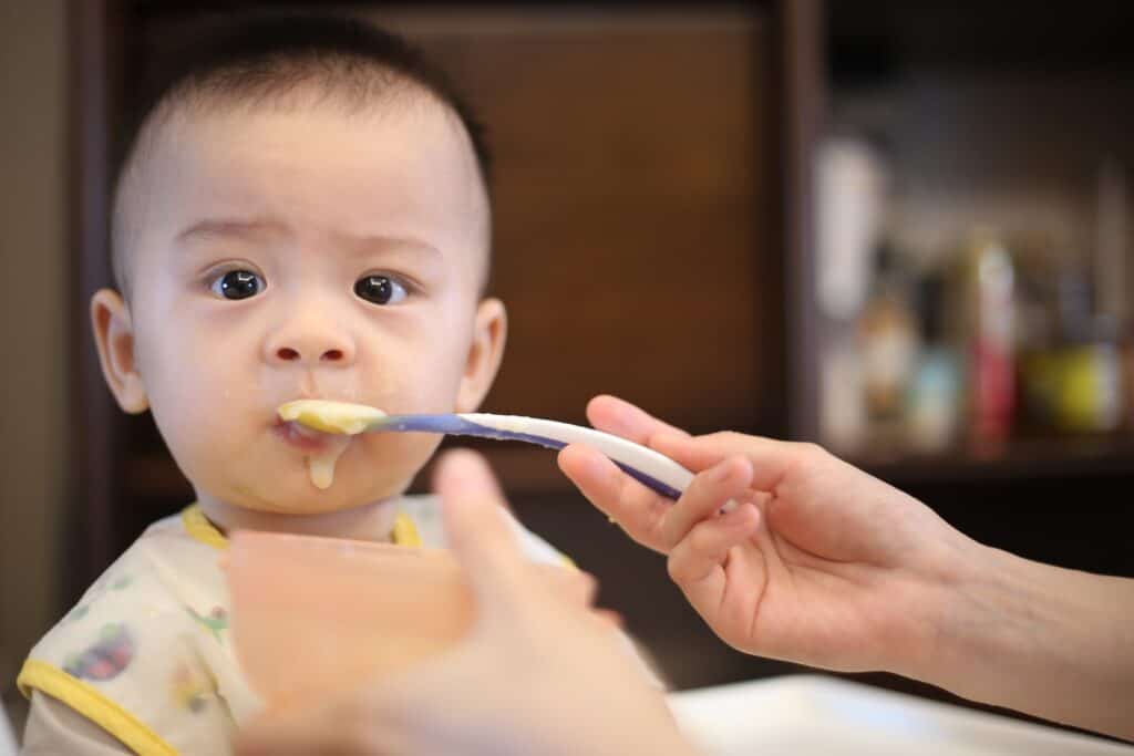 Cute baby eating organic baby cereal. 